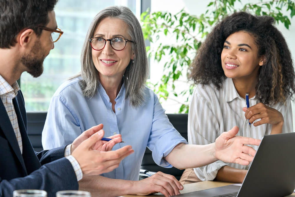 Image of people sitting at a table talking in a meeting room.